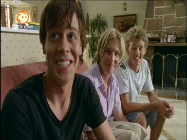 Zwei junge Mnner nehmen Lewis in ihre Mitte.